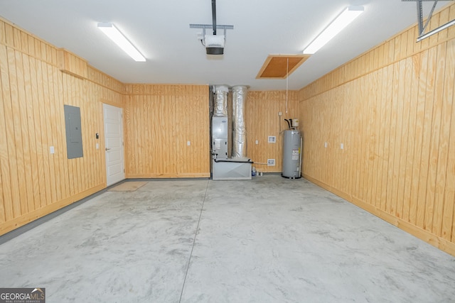 garage featuring electric panel, water heater, heating unit, and wood walls