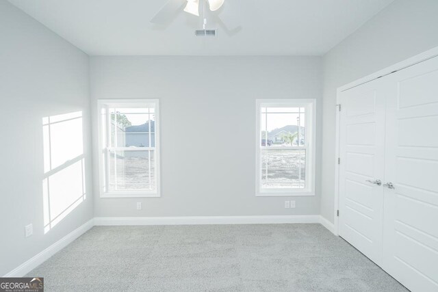 184 The Villas Way, Kingsland, GA 31548 - unfurnished bedroom with ceiling fan, multiple windows, and light colored carpet