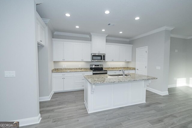 184 The Villas Way, Kingsland, GA 31548 - kitchen with sink, light stone counters, appliances with stainless steel finishes, a kitchen island with sink, and white cabinets
