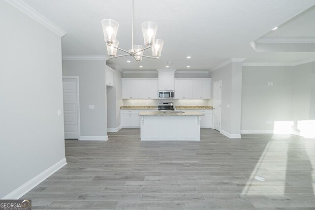 184 The Villas Way, Kingsland, GA 31548 - kitchen with a center island with sink, white cabinets, hanging light fixtures, ornamental molding, and light stone countertops