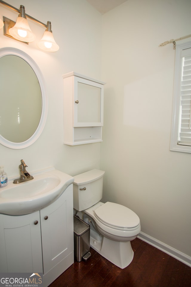 bathroom with hardwood / wood-style floors, vanity, and toilet