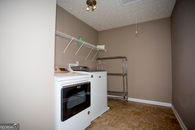 clothes washing area featuring separate washer and dryer and a textured ceiling