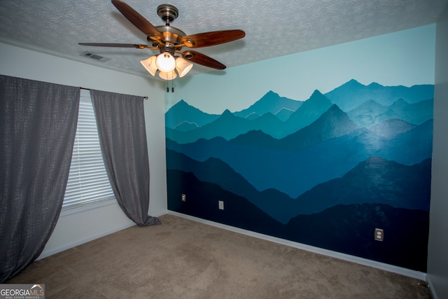 carpeted spare room featuring a textured ceiling and ceiling fan