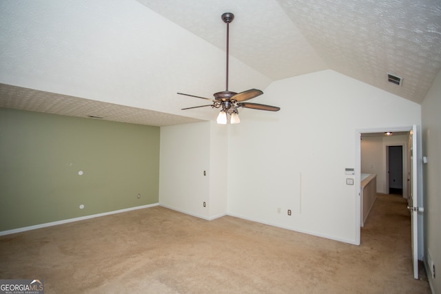 carpeted empty room featuring lofted ceiling, a textured ceiling, and ceiling fan