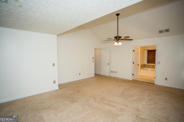 carpeted spare room with ceiling fan, a textured ceiling, and vaulted ceiling