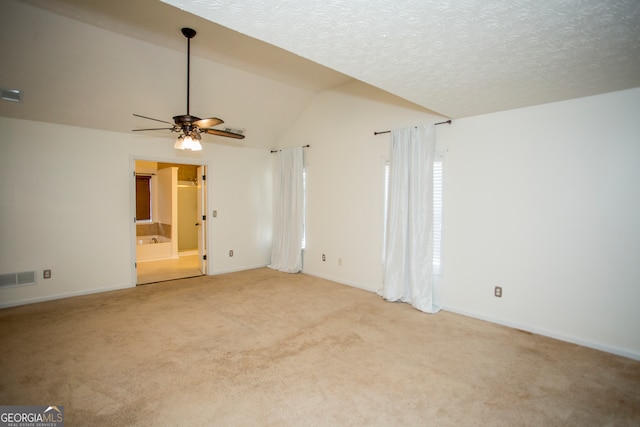 empty room featuring ceiling fan, a textured ceiling, light carpet, and vaulted ceiling