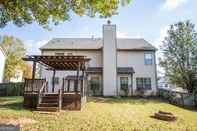 back of house featuring a pergola, a lawn, an outdoor fire pit, and a deck