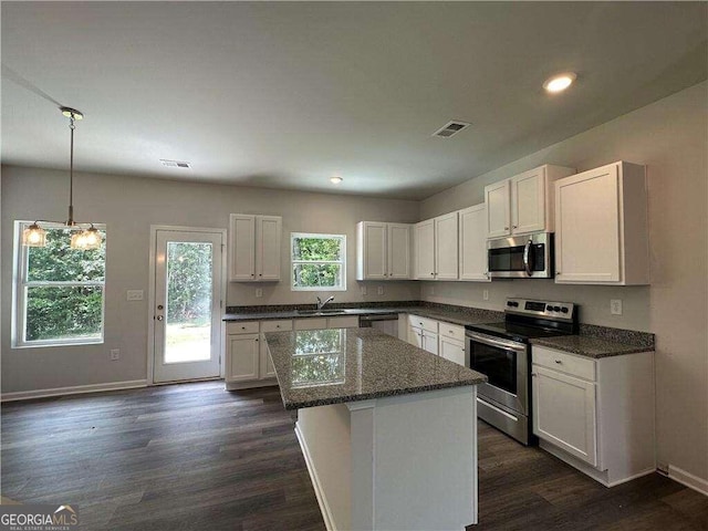 kitchen with a center island, sink, white cabinetry, and stainless steel appliances