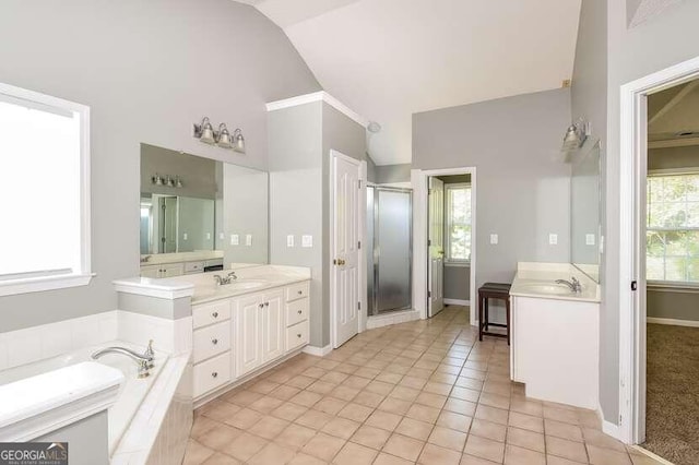 bathroom with tile patterned flooring, lofted ceiling, a healthy amount of sunlight, and vanity