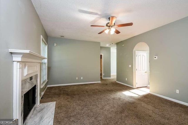 unfurnished living room featuring carpet, a textured ceiling, and ceiling fan