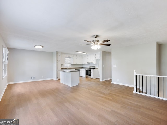 unfurnished living room with ceiling fan, sink, and light wood-type flooring