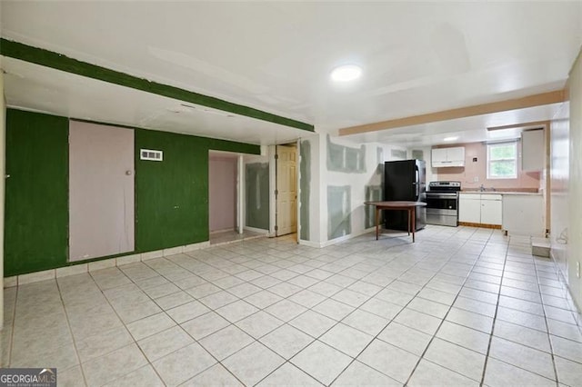 unfurnished living room with light tile patterned floors and sink