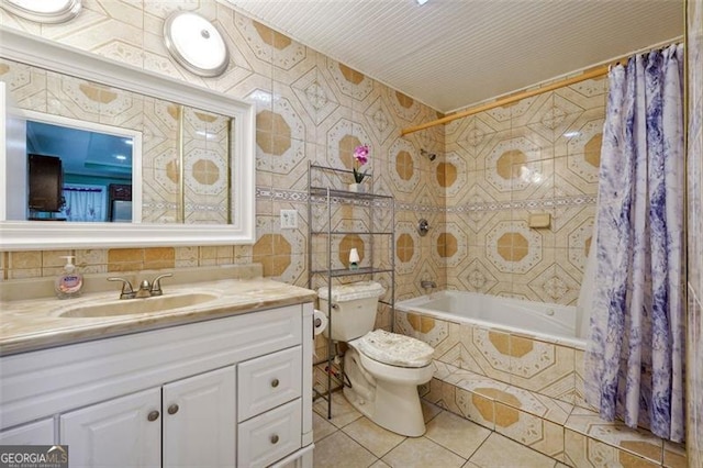 full bathroom with shower / bathtub combination with curtain, vanity, tile patterned floors, toilet, and tile walls