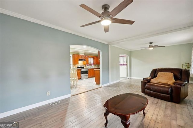 living room with light wood-type flooring, ceiling fan, and crown molding