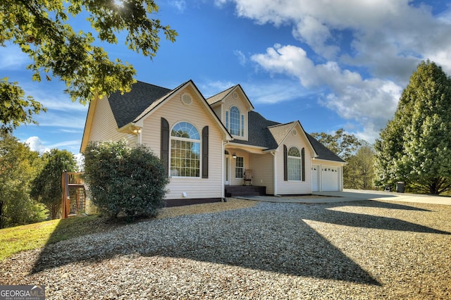 view of front of house featuring driveway, a shingled roof, and an attached garage