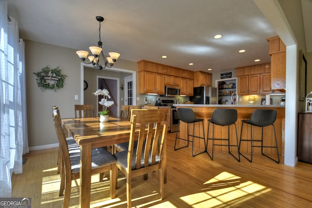 dining space featuring light hardwood / wood-style flooring and an inviting chandelier