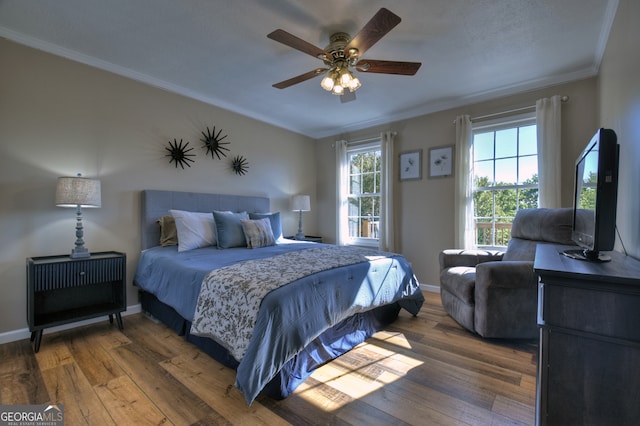 bedroom with hardwood / wood-style floors, ceiling fan, and crown molding