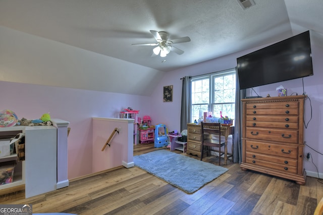 rec room featuring a textured ceiling, hardwood / wood-style floors, ceiling fan, and vaulted ceiling