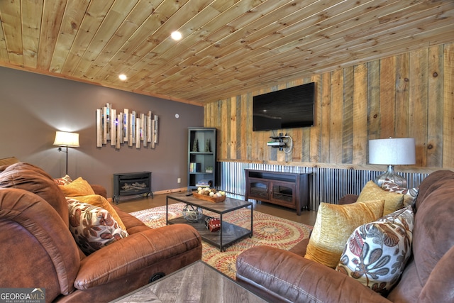 living room featuring wood walls, hardwood / wood-style flooring, wood ceiling, and a wood stove