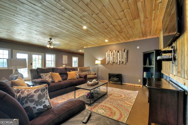 living room with a wood stove, wooden ceiling, and ceiling fan