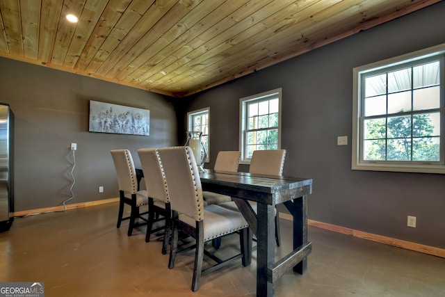 dining space featuring wood ceiling and concrete floors