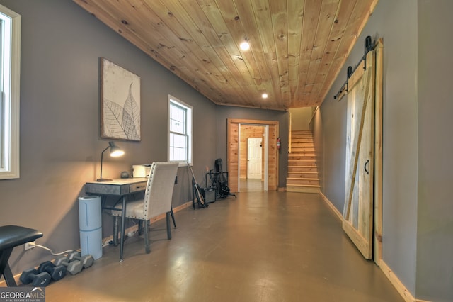 interior space featuring a barn door, wooden ceiling, and concrete floors