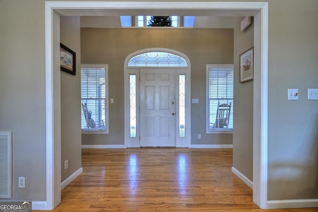 entryway with light wood-style flooring, visible vents, and baseboards