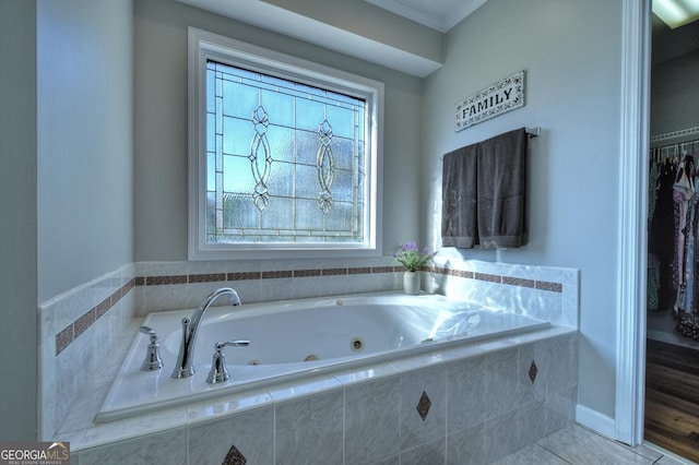 bathroom featuring a jetted tub, crown molding, and tile patterned floors