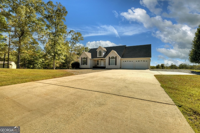 cape cod home featuring a garage and a front lawn