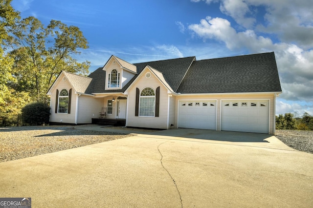 view of front of house with driveway, a shingled roof, and an attached garage