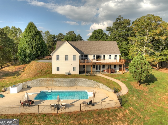 rear view of house featuring a fenced in pool, a patio area, a lawn, and a balcony