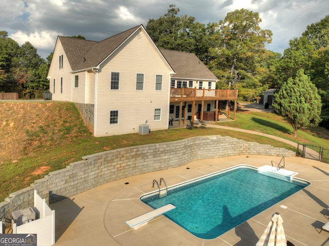 rear view of property featuring central AC, a patio area, a lawn, and a pool side deck