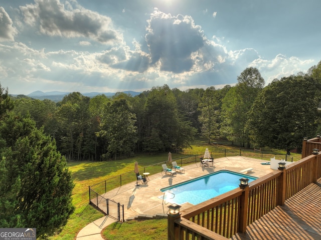 view of swimming pool with a diving board, a lawn, and a patio