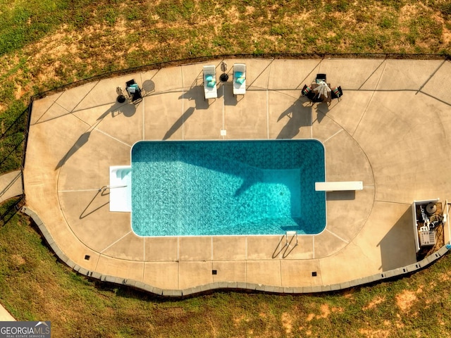 view of swimming pool featuring a diving board