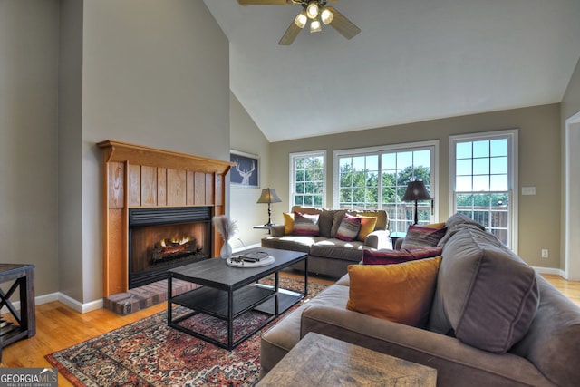 living room featuring high vaulted ceiling, light hardwood / wood-style floors, and ceiling fan