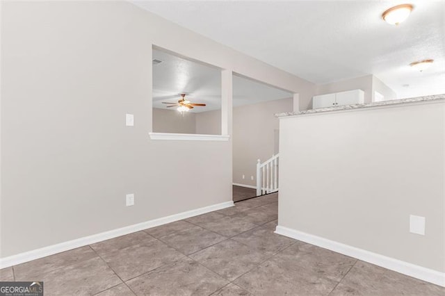 tiled spare room with ceiling fan