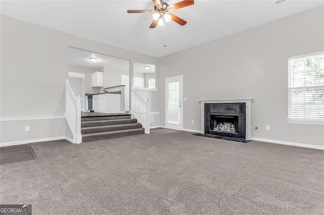 unfurnished living room featuring a healthy amount of sunlight and carpet