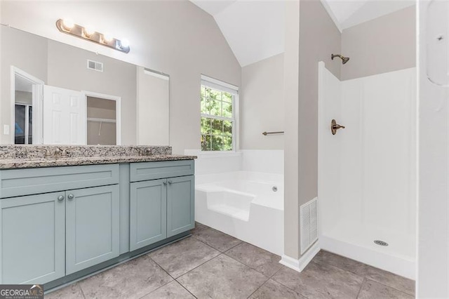 bathroom featuring shower with separate bathtub, vanity, tile patterned floors, and vaulted ceiling