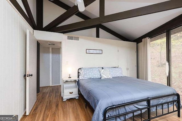 bedroom with hardwood / wood-style floors, ceiling fan, high vaulted ceiling, and beam ceiling