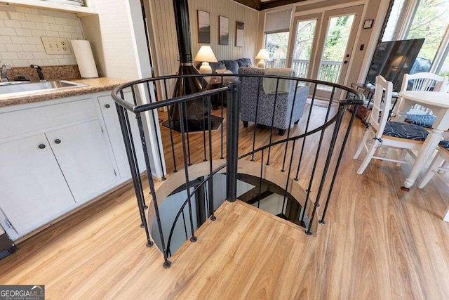 staircase with sink and hardwood / wood-style flooring