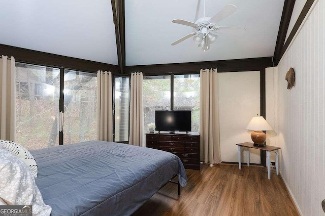 bedroom with lofted ceiling with beams, hardwood / wood-style floors, and ceiling fan