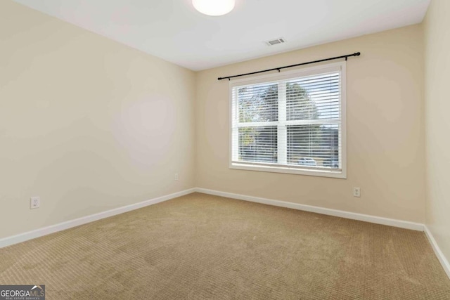 empty room with light colored carpet and a healthy amount of sunlight