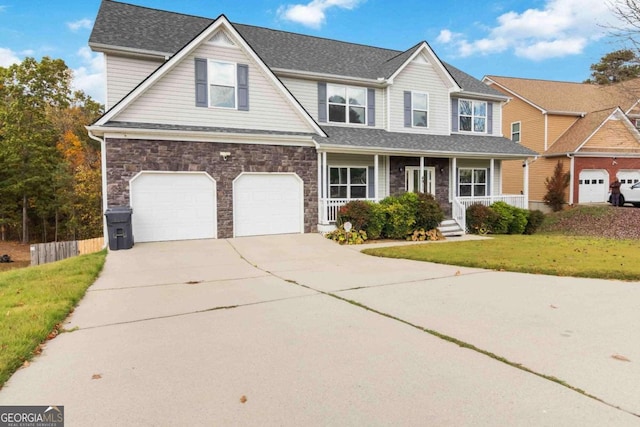 view of front of home with a garage, a front yard, and a porch