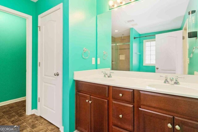 bathroom with vanity and a shower with door