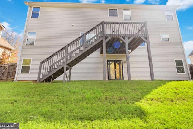 rear view of property featuring a lawn and a deck