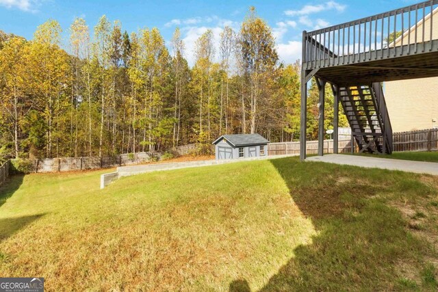 view of yard with a wooden deck and a storage unit