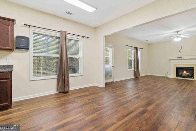 unfurnished living room with dark wood-type flooring and ceiling fan