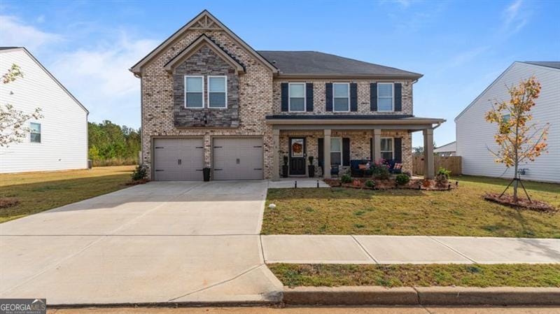 view of front of property featuring a garage, a front yard, and covered porch