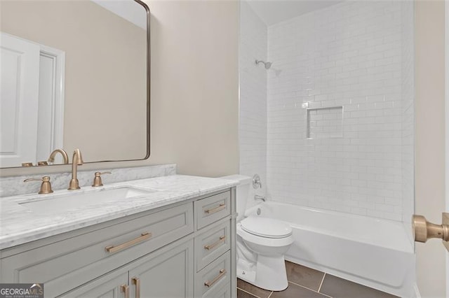 full bathroom featuring tile patterned flooring, vanity, toilet, and tiled shower / bath combo