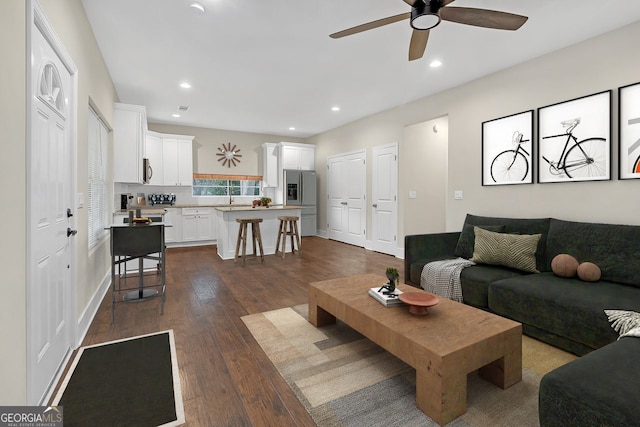 living room with dark hardwood / wood-style floors and ceiling fan